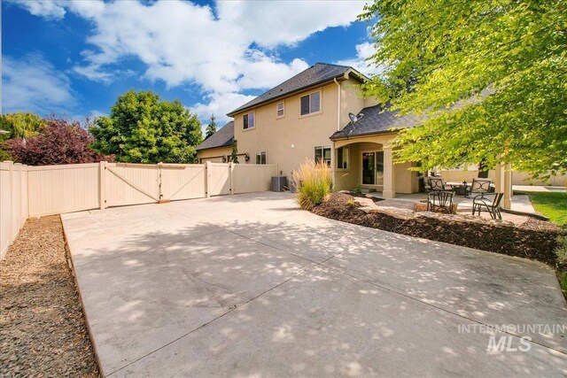 back of property with central air condition unit and a patio area