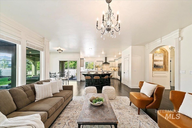 living room with dark hardwood / wood-style flooring and a notable chandelier