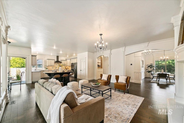 living room with dark hardwood / wood-style flooring, decorative columns, a wealth of natural light, and sink