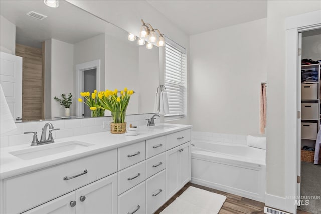 6413 E E Path, Nampa, ID 83687 - bathroom with double vanity, a garden tub, and wood finished floors