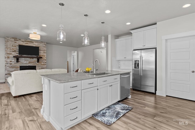 6413 E E Path, Nampa, ID 83687 - kitchen featuring stainless steel appliances, a sink, light wood-type flooring, recessed lighting, and a stone fireplace