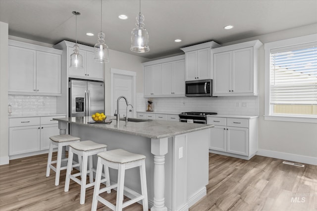 6413 E E Path, Nampa, ID 83687 - kitchen with stainless steel appliances, a sink, a breakfast bar area, recessed lighting, and light wood finished floors