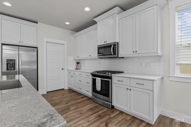 6413 E E Path, Nampa, ID 83687 - kitchen with appliances with stainless steel finishes, dark wood-style floors, white cabinets, backsplash, and recessed lighting