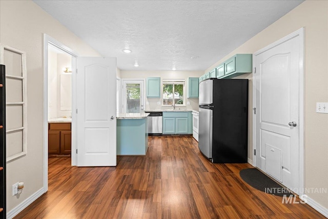 2972 N Saint James Pl, Boise, ID 83703 - kitchen featuring appliances with stainless steel finishes, blue cabinetry, dark wood finished floors, light countertops, and a textured ceiling