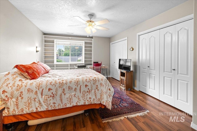 2972 N Saint James Pl, Boise, ID 83703 - bedroom with multiple closets, a textured ceiling, dark wood finished floors, and a ceiling fan