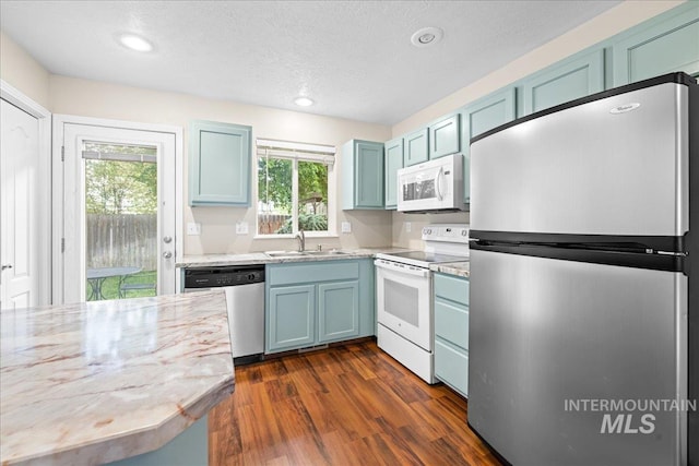2972 N Saint James Pl, Boise, ID 83703 - kitchen with stainless steel appliances, blue cabinetry, dark wood-type flooring, a textured ceiling, and recessed lighting