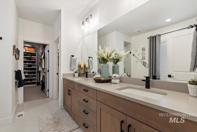 203 S Fusion Ave, Kuna, ID 83634 - bathroom with double vanity, a stall shower, a spacious closet, and tile patterned flooring