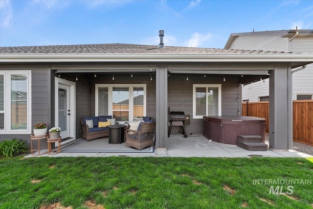 203 S Fusion Ave, Kuna, ID 83634 - back of property featuring a hot tub, a patio area, an outdoor living space, and a shingled roof