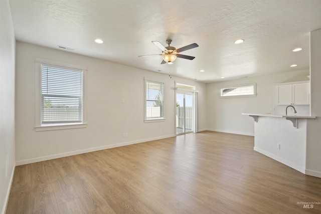 10663 W Catmint, Star, ID 83669 - unfurnished living room with a ceiling fan, baseboards, recessed lighting, and light wood-style flooring