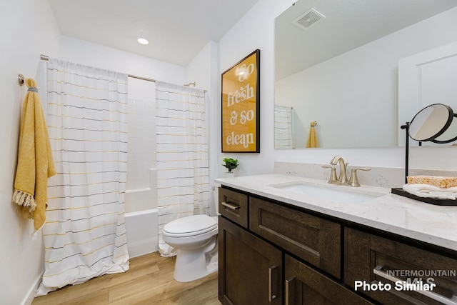 full bathroom featuring wood finished floors, toilet, vanity, and shower / bath combination with curtain