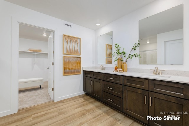 full bathroom with wood finished floors, double vanity, baseboards, recessed lighting, and an enclosed shower