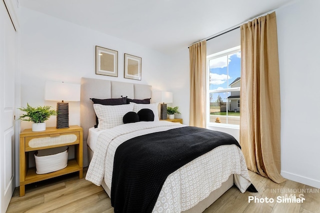 bedroom with wood finished floors and baseboards