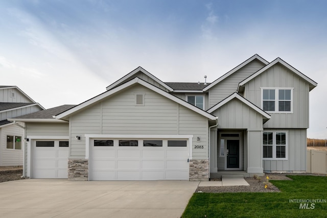 craftsman house with a garage, stone siding, board and batten siding, and concrete driveway