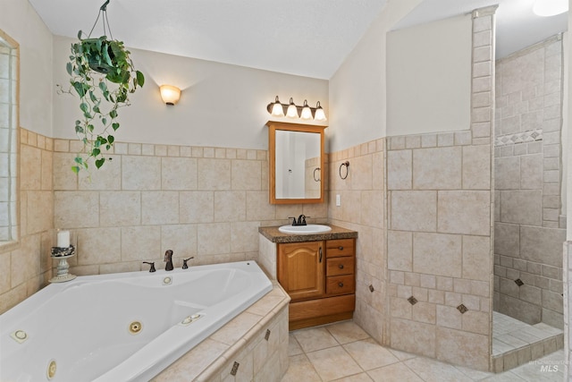 full bath featuring tile walls, a jetted tub, vanity, tile patterned floors, and a tile shower