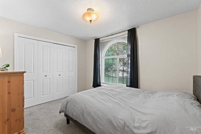 bedroom with carpet flooring, a closet, and a textured ceiling