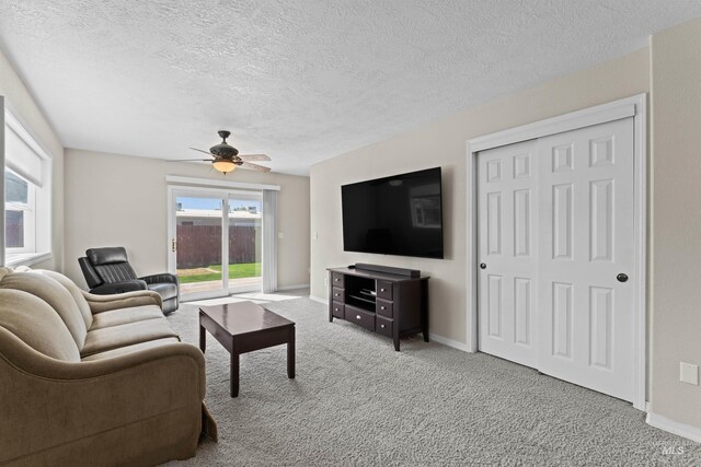 carpeted living room with a ceiling fan, a textured ceiling, and baseboards
