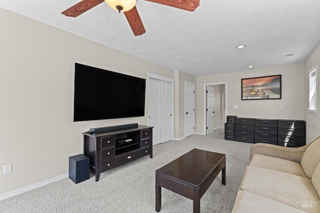 carpeted living area with baseboards, ceiling fan, a textured ceiling, and recessed lighting