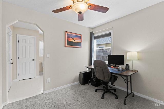 office with arched walkways, carpet floors, ceiling fan, and baseboards