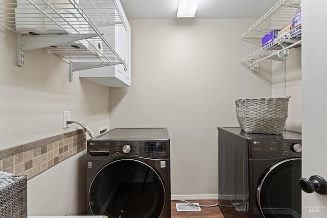 laundry room featuring washing machine and dryer, wood finished floors, and baseboards