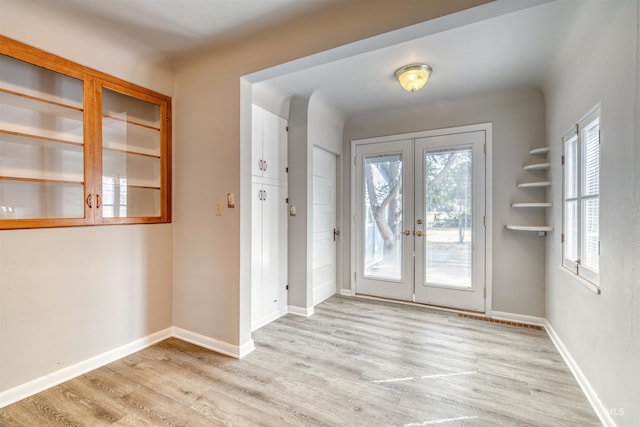 doorway to outside featuring french doors, plenty of natural light, and light wood-type flooring