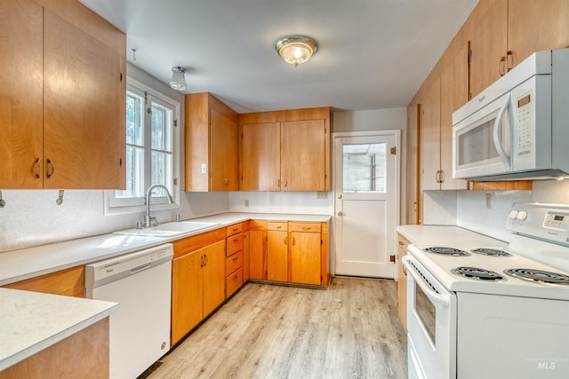 kitchen featuring sink, white appliances, and light hardwood / wood-style flooring