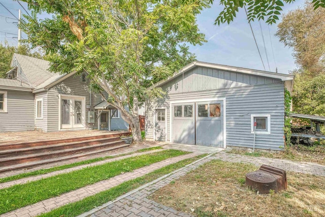 back of property featuring french doors and a garage