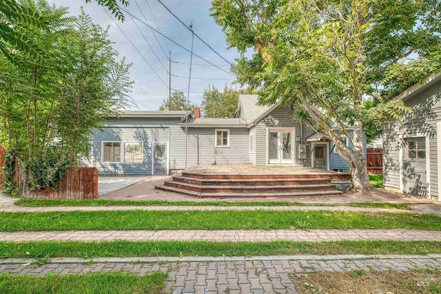 back of house featuring a lawn and a deck