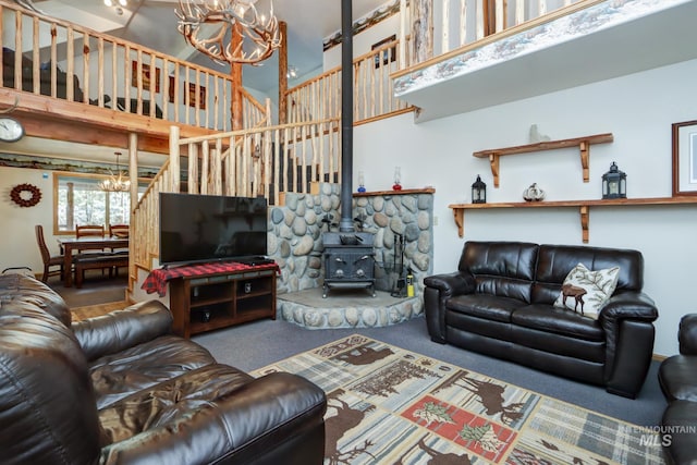 351 Estate Dr, Cascade, ID 83611 - living room with a wood stove, a high ceiling, an inviting chandelier, and carpet