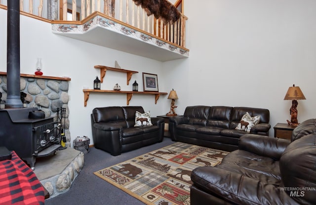 351 Estate Dr, Cascade, ID 83611 - living area featuring a wood stove, a high ceiling, and carpet flooring