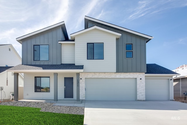 view of front facade featuring a garage, a shingled roof, concrete driveway, a porch, and board and batten siding