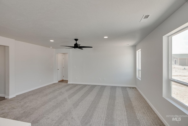 unfurnished room with a textured ceiling, recessed lighting, carpet, and baseboards