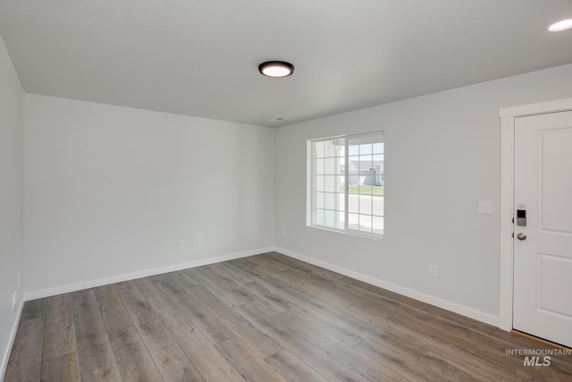 spare room featuring light wood-style floors and baseboards