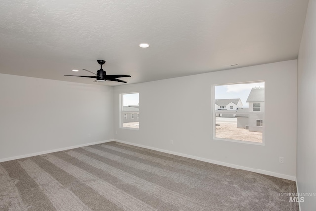 carpeted spare room with a textured ceiling, ceiling fan, recessed lighting, and baseboards