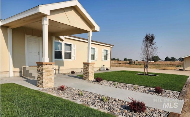 view of home's exterior with a lawn and stucco siding