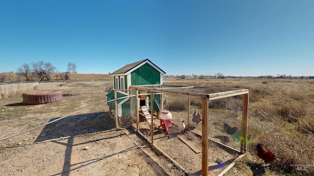 view of playground with an outbuilding, a rural view, and exterior structure