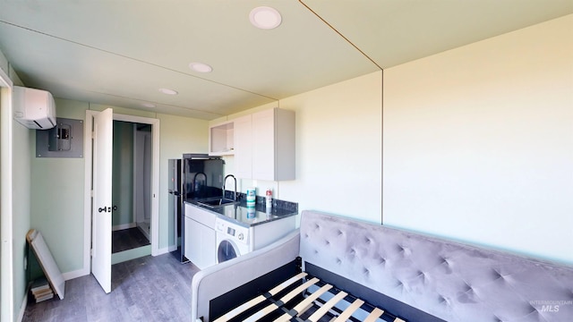 kitchen featuring a sink, washer / clothes dryer, dark countertops, a wall unit AC, and stove