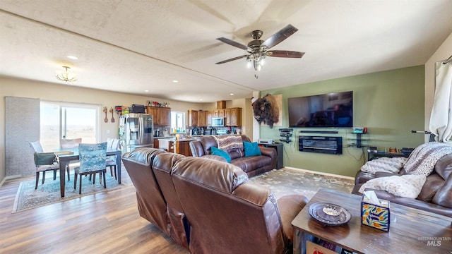 living room with recessed lighting, light wood-style flooring, baseboards, and ceiling fan