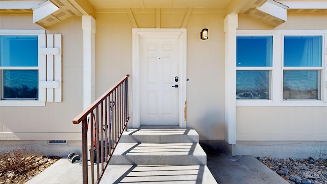 property entrance with crawl space and stucco siding