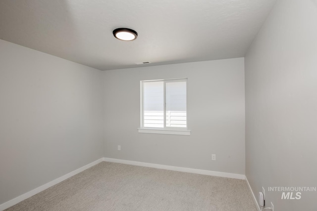 empty room featuring baseboards and carpet floors