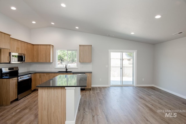 kitchen featuring a sink, stainless steel appliances, light wood-type flooring, visible vents, and lofted ceiling