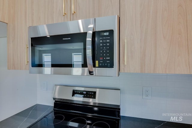 interior details with light brown cabinets, modern cabinets, backsplash, dark countertops, and stainless steel appliances