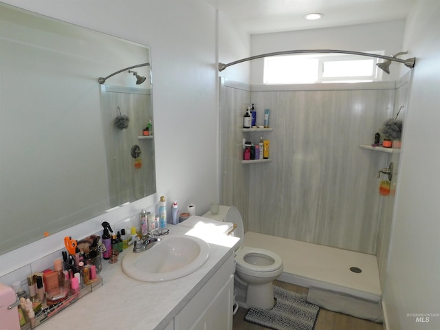 bathroom featuring toilet, vanity, and walk in shower