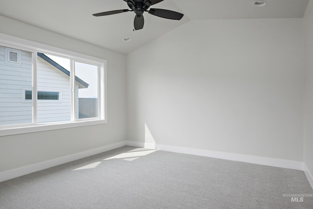 carpeted empty room featuring vaulted ceiling and ceiling fan