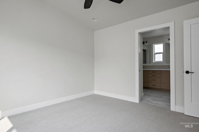 unfurnished bedroom with carpet flooring, ensuite bathroom, and ceiling fan