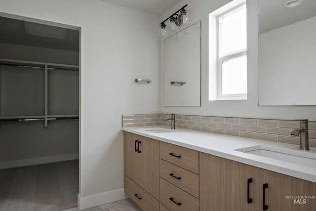 bathroom with vanity and tasteful backsplash