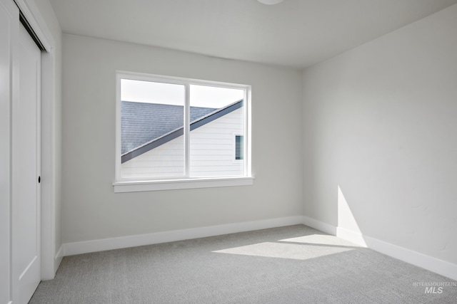 unfurnished bedroom featuring light colored carpet and a closet