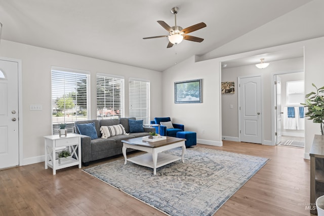 living room featuring ceiling fan, hardwood / wood-style floors, and vaulted ceiling