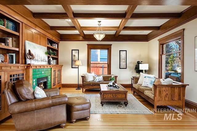 living room featuring a healthy amount of sunlight, coffered ceiling, beam ceiling, and light hardwood / wood-style flooring