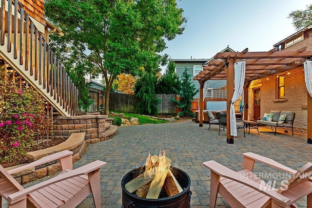 view of patio with a pergola and an outdoor living space with a fire pit