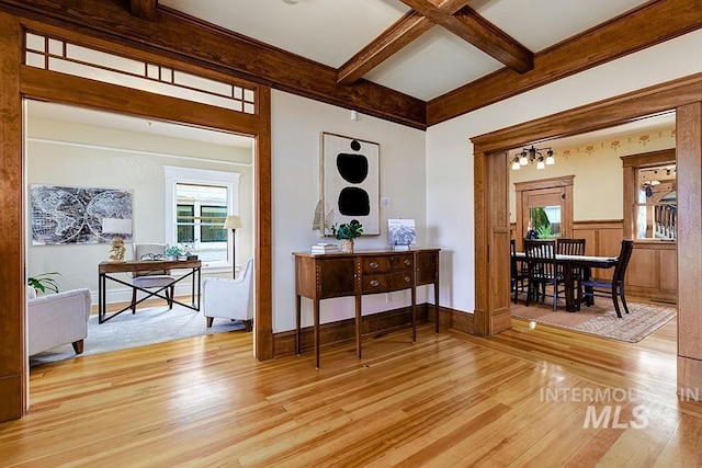 interior space with beam ceiling, coffered ceiling, and light wood-type flooring